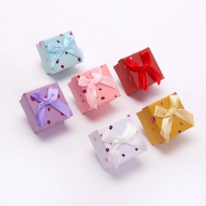 Close-up of six colorful jewelry boxes with ribbon bows and glossy polka dot patterns