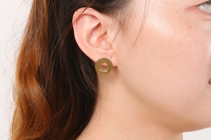 Close-up of elegant gold hollow circular earrings with crystal inlay on a model