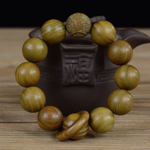 Détail de perles en bois de santal naturel sur une théière en céramique artisanale