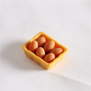 Macro shot of miniature yellow egg tray with six brown resin eggs for dollhouse decor