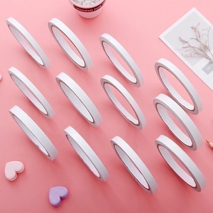 Set of 12 rolls white double-sided adhesive tapes on a pink decorative background