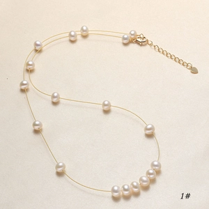 Detail view of freshwater pearl necklace with golden chain and adjustable lobster clasp