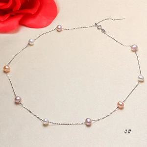 Close-up of multicolor freshwater pearl necklace with silver chain on textured fabric