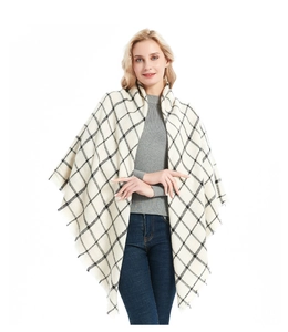 Detail shot of cream and black checkered shawl featuring fringe tassels and knit texture