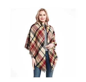 Detailed view of women's oversized plaid scarf with tassels worn as a colorful shawl