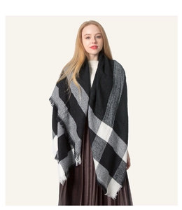 Close-up of soft black and white plaid scarf with decorative fringe tassels details