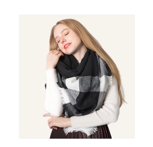 Close-up of black and white plaid knit scarf with soft tassel edges for winter style