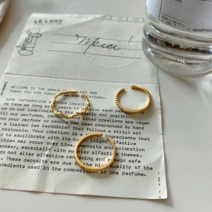 Three-piece set of gold minimalist rings featuring wave texture and beaded open design