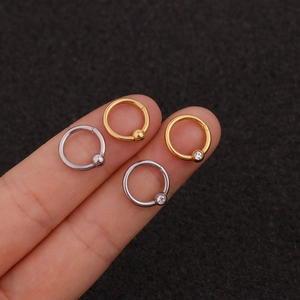 Detailed close-up of stainless steel nose rings with zircon in gold and silver finishes