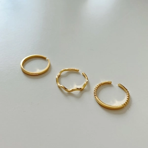 Macro shot of three stacked S925 sterling silver gold rings with smooth and beaded textures