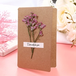 Detail of kraft paper greeting card with dried pink flowers and 'Especially for you' note