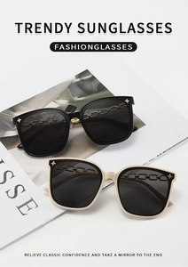 Détail de lunettes de soleil carrées avec chaîne dorée et clous en forme d'étoile