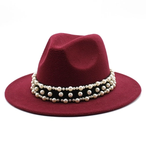 Macro shot of burgundy wool fedora hat featuring triple-row pearl embellishments on black band
