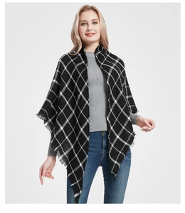 Detail of black plaid cashmere-like triangle scarf featuring classic tassel fringe edges