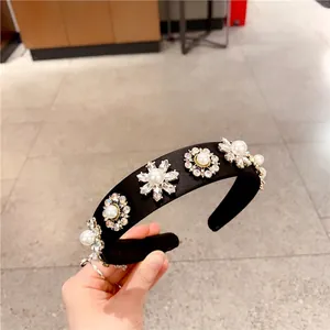 Detail of vintage headband with black satin base, white pearls, and sparkling crystals
