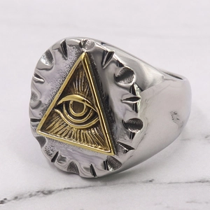 Macro view of vintage stainless steel ring with golden All-Seeing Eye triangle relief