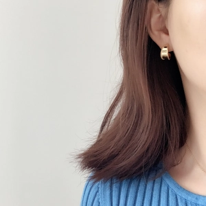 Detail of wide gold hoop earring with beaded edges worn on model for a French vintage look