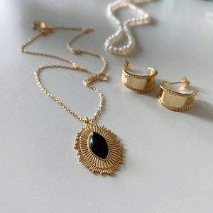 Detail of 925 silver gold necklace with black agate stone and matching hoop earrings set