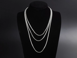 Close-up of triple-layered silver tennis necklace with sparkling round-cut crystals