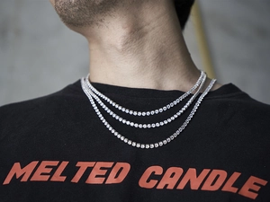 Close-up of triple layered silver tennis necklaces with shiny cubic zirconia on model neck