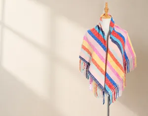 Detail eines bunten gestreiften Strickschals mit rosa-orangefarbenen Mustern und Fransen