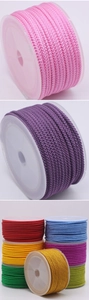 Detail of 3mm braided cords in vibrant colors on spools for DIY jewelry making