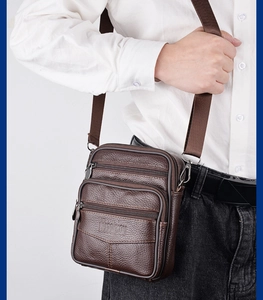 Detailed view of brown lychee grain leather crossbody bag with three zipper pockets