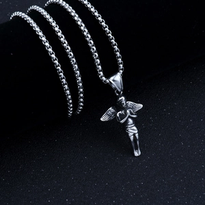 Detailed view of silver angel pendant on box chain over a dark minimalist background