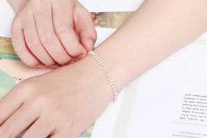 Gros plan d'un bracelet double rang en argent avec pierres colorées au poignet