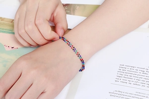 Bracelet bohème fait main avec perles colorées et pierres fines sur un poignet féminin