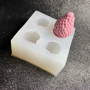 Makroaufnahme der 3D Erdbeere Silikonform mit einem fertigen rosa Erdbeermodell aus Harz