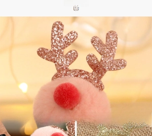 Macro shot of rose gold sequined reindeer antlers and pink plush ball for festive hair clips