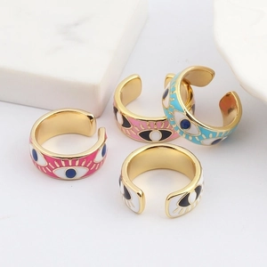 Colorful Evil Eye enamel open rings in gold finish shown on white marble props