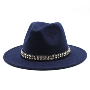 Détail d'un chapeau Fedora en laine avec des clous argentés sur ruban noir