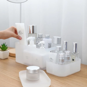 Close-up of translucent white plastic makeup organizers on a wooden desk setup