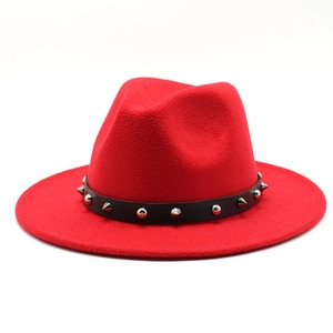 Detailed macro view of the red wool felt fedora featuring a studded black leather belt strap