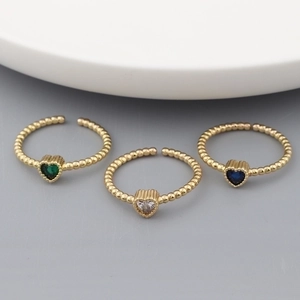 Three 18k gold plated heart-shaped rings with colorful zircon stones in a stylish display