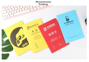 Close-up of colorful A5 student notebooks with custom screen-printed covers and logos