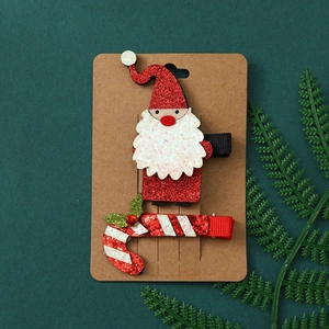 Christmas hair clips set featuring Santa Claus and candy cane designs on a green background