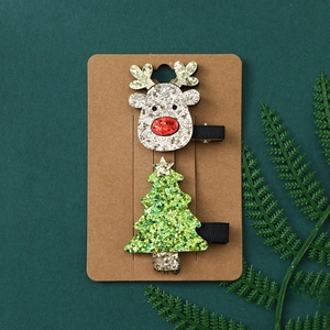 Detail of Christmas hair clips set with silver glitter reindeer and green glitter tree