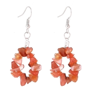 Detailed close-up of orange crushed stone bead hoop earrings with silver hooks