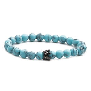 Stack of 8mm blue turquoise bead bracelets with a black crown charm on white background