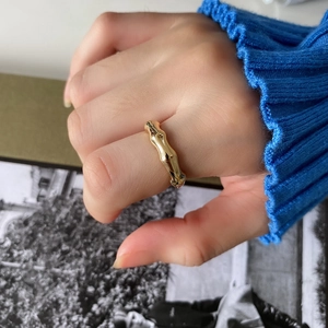 Detailed view of a gold bamboo textured sterling silver ring worn on a finger