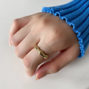 Macro shot of 925 sterling silver golden wave ring with organic bamboo-inspired texture