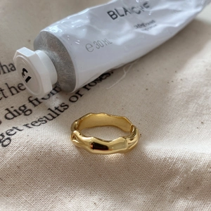 Detail of gold bamboo style silver ring on beige linen cloth with soft lighting