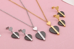 Vue détaillée des colliers et boucles d'oreilles cœur dorés et argentés gravés I Love You