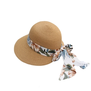 Women's summer straw hat with wide brim and tropical floral ribbon bow decoration