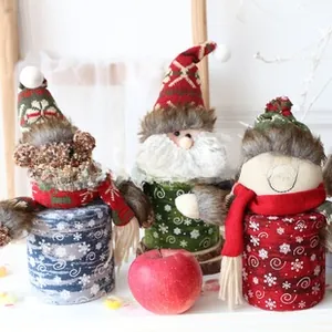 Close-up of festive Christmas candy jars with Santa, bear and snowman knit plush covers