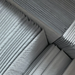 Waterproof grey bubble mailers stacked in bulk showing textured cushioning for shipping