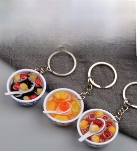 Detail of miniature blue and white porcelain bowl charms with realistic resin desserts